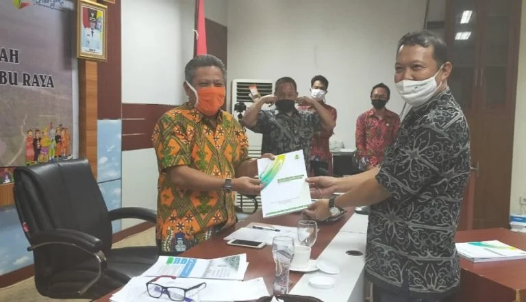 Bupati Kubu Raya Muda Mahendrawan menerima laporan pelaksanaan program Desa Peduli Gambut yang diserahkan oleh Hermawansyah, Dinamisator BRG Kalimantan Barat/ Istimewa