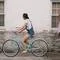 woman riding on teal cruiser bike near woman wearing pink long sleeved shirt