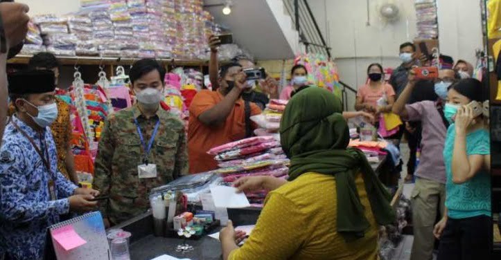 Wali Kota Surakarta Gibran Rakabuming Raka (dua dari kiri) didampingi Camat Pasar Kliwon Ari Dwi Daryanto (paling kiri) saat mengembalikan uang pungli dan meminta maaf kepada pemilik toko di Kelurahan Gajahan Pasar Kliwon Solo, Minggu (0205/2021)